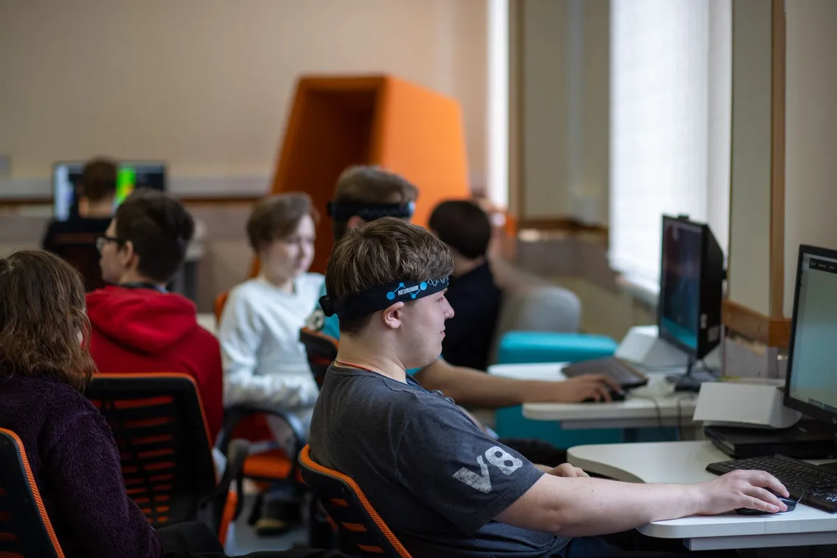 Teenagers working at computers in a classroom